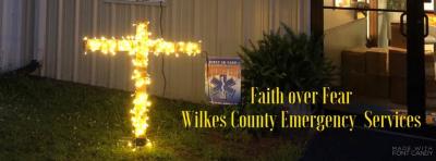 Image of a lit up cross with the words faith over fear